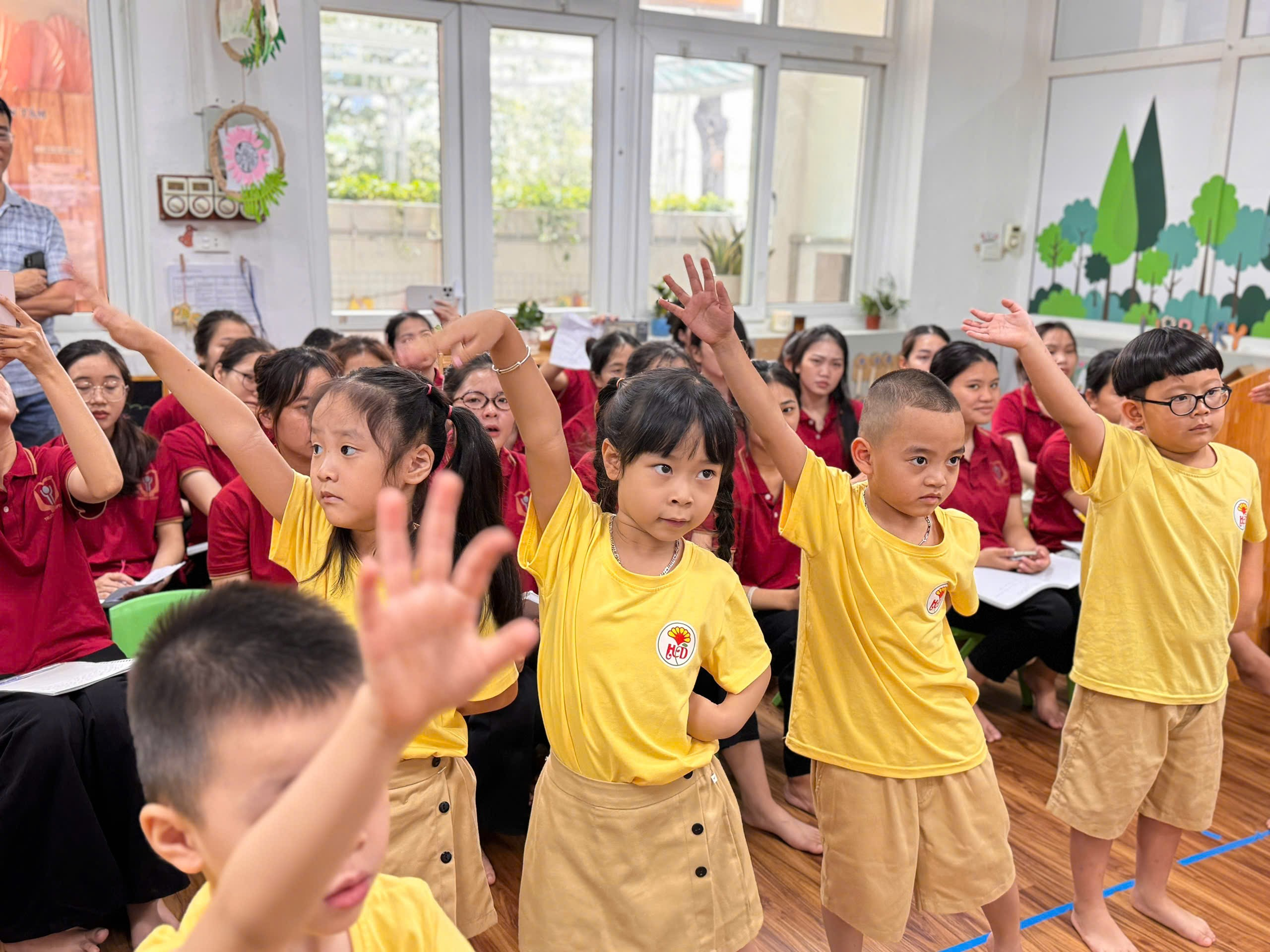 A group of children raising their hands
AI-generated content may be incorrect.