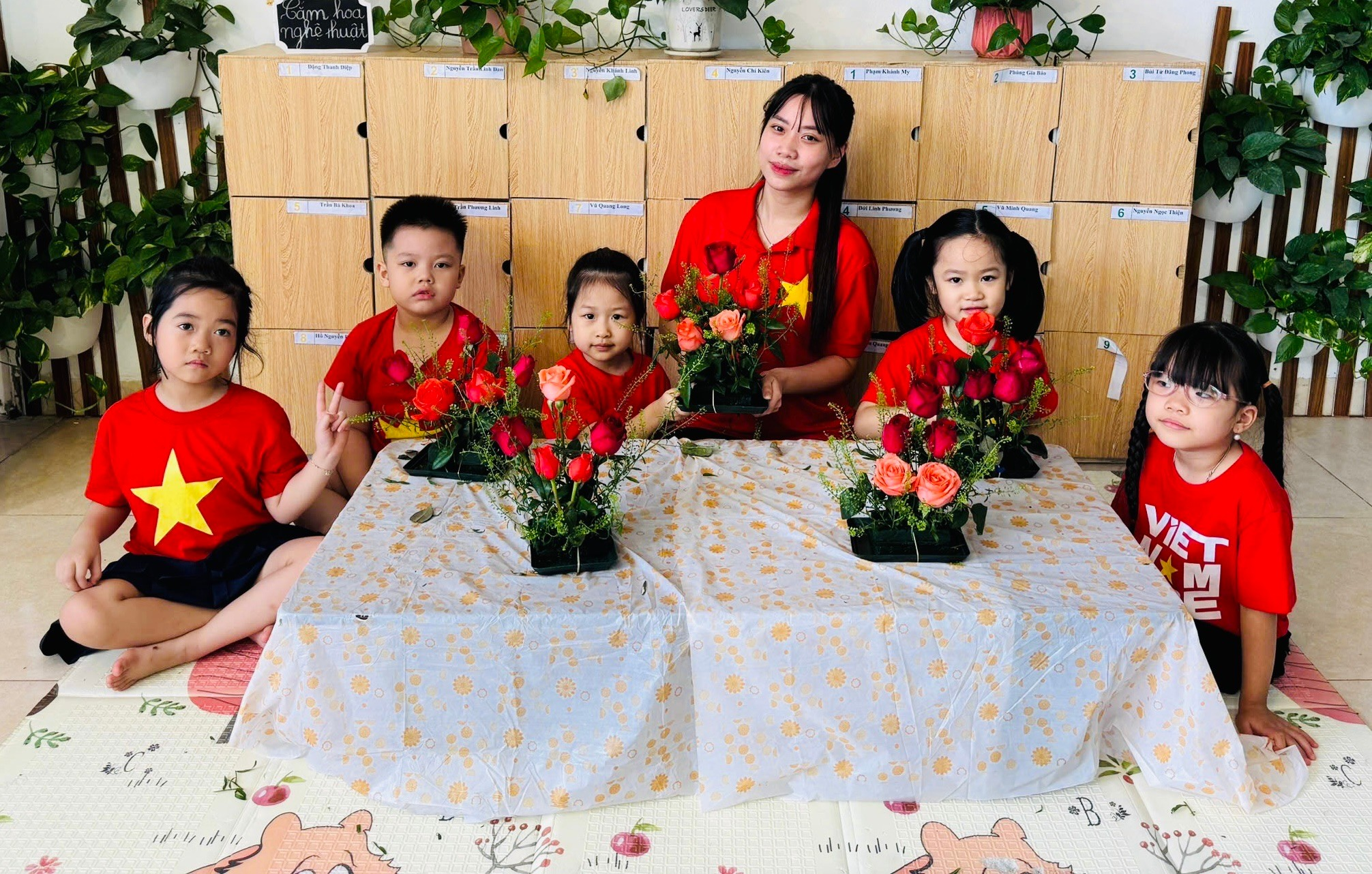 A group of children sitting at a table with flowers
AI-generated content may be incorrect.