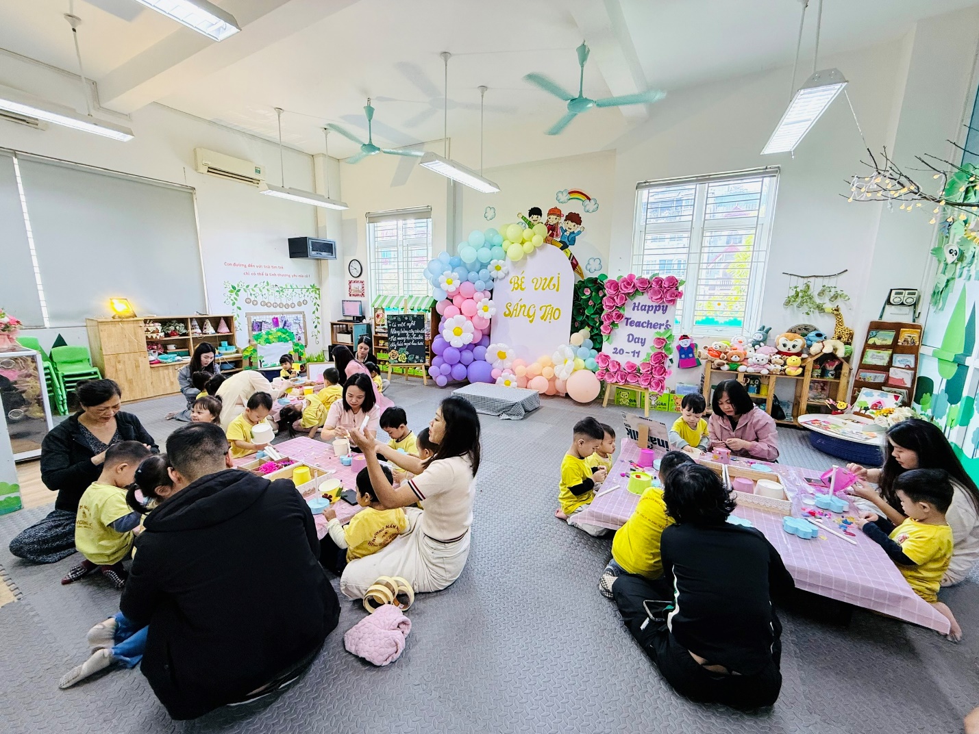 A group of people sitting on the floor in a room with balloons

AI-generated content may be incorrect.
